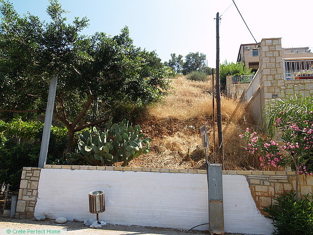 Sloping plot in village centre, sea & mountain views